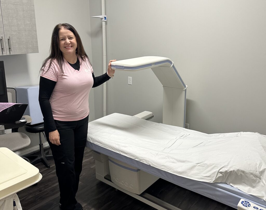 Woman beside DEXA machine